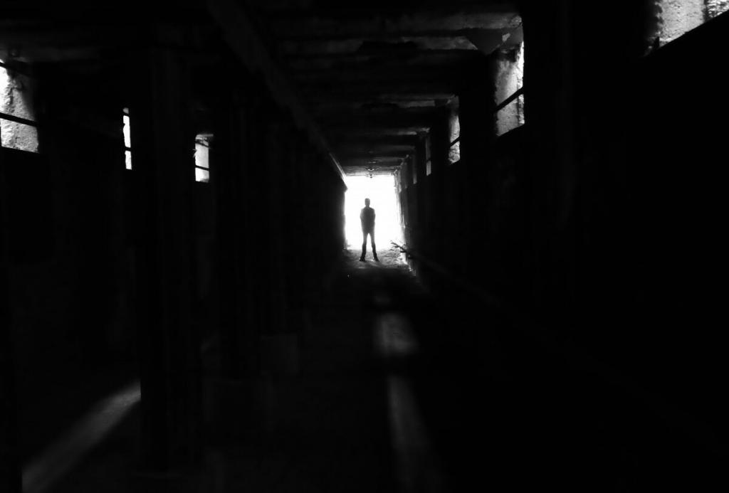 Shadow of man standing in dark tunnel