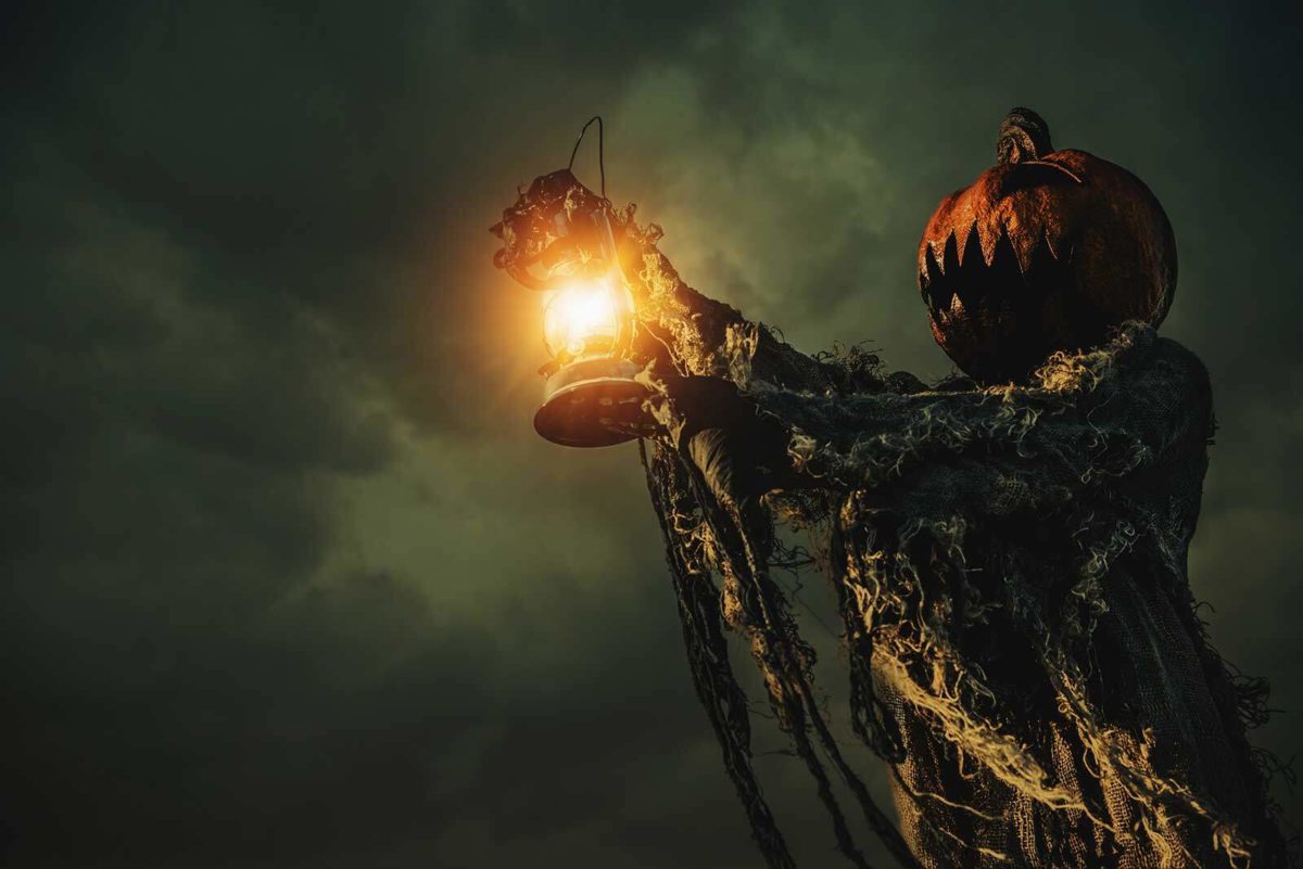 Scary Halloween pumpkin man holding a latern