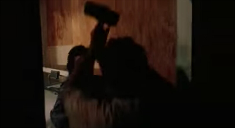 Leather face attacking a victim with a hammer